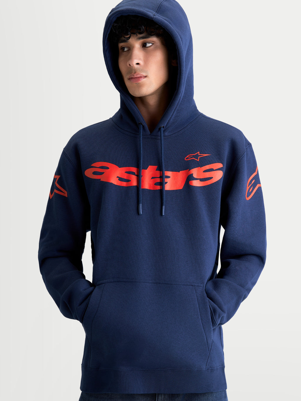 Alpinestars Velocifier hoodie, unisex sportswearpullover van fleece, marineblauw met rode Astars-branding, model draagt hoodie met gebogen woordmerk op de voorzijde, logo's op de schouders en een capuchon met trekkoord
