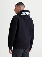Alpinestars Pioneer Oversized Hoodie, heren-sportswear lifestyle-hoodie met ritssluiting, zwart en wit, ontspannen oversized pasvorm, met wit geborduurd ASTARS-logo op de capuchon, premium katoen-fleece constructie, achteraanzicht op model.