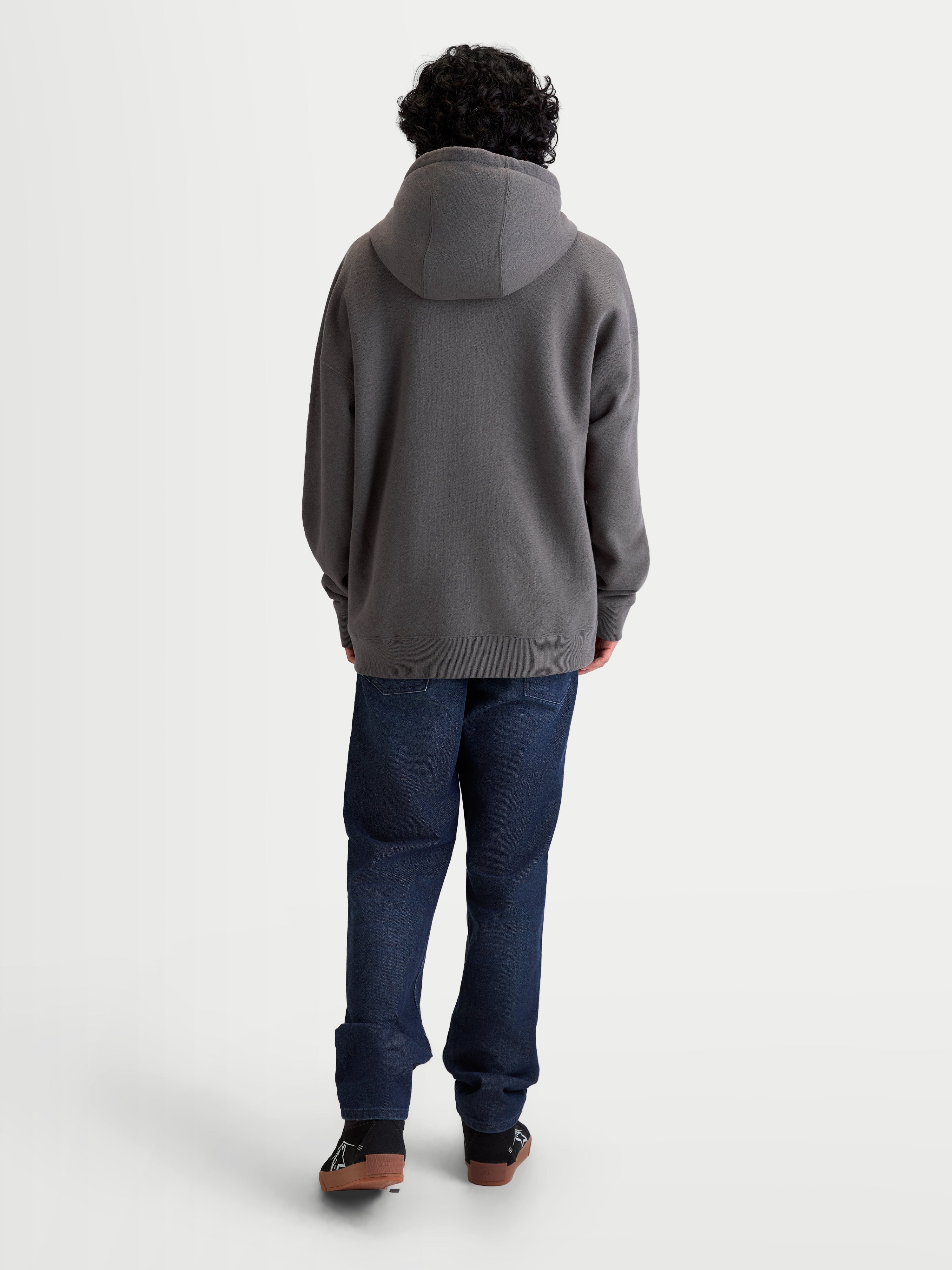 Alpinestars Entity Oversized hoodie, sportswear fleecevest met rits, unisex, grijs, achteraanzicht op model met een relaxte pasvorm, zelfgevoerde capuchon en ribboorden, gemaakt van katoen en gerecycled polyester.