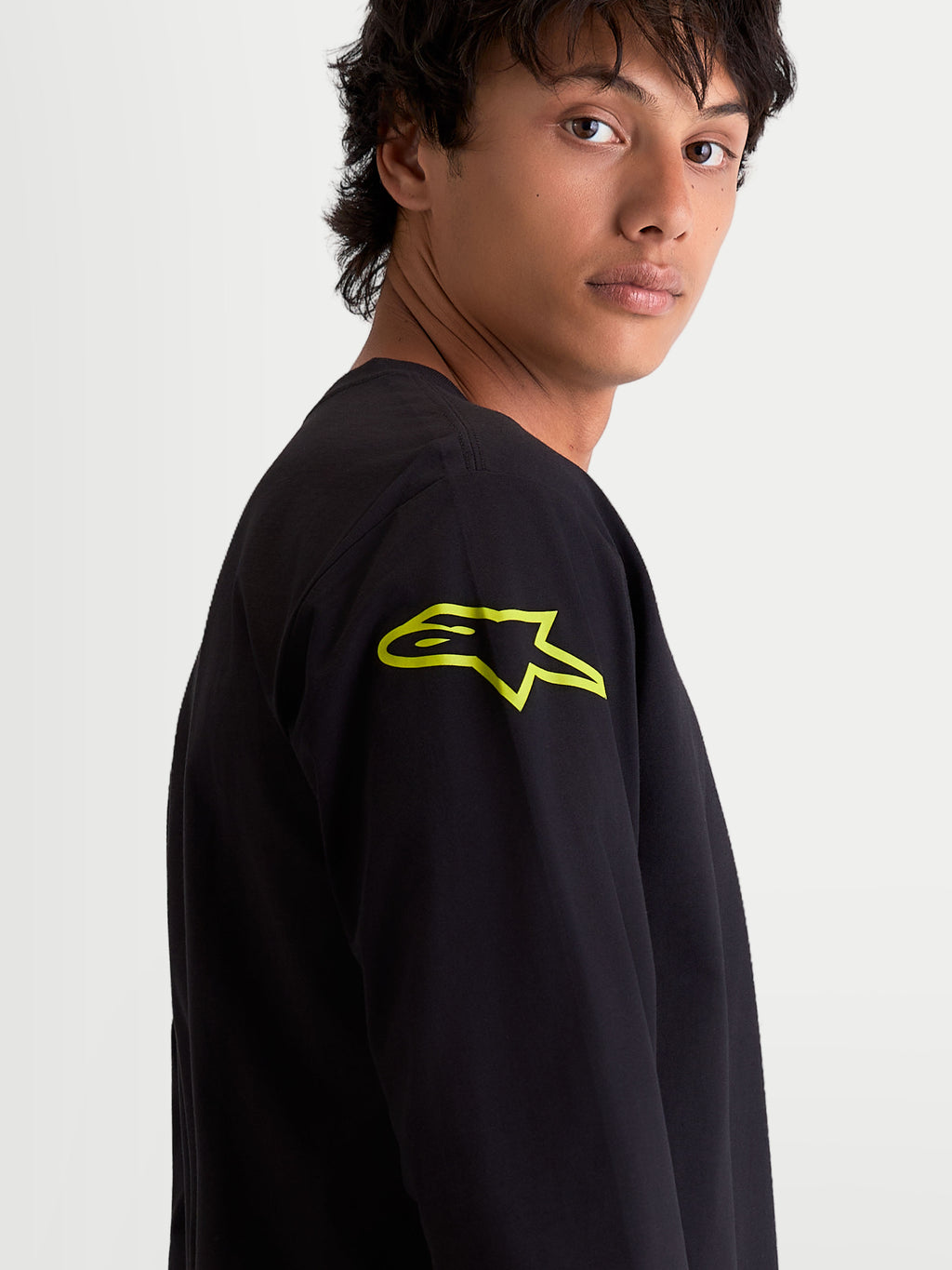 Alpinestars Velocifier CSF t-shirt, heren-t-shirt met lange mouwen, zwart met een felgeel Astars-logo op de schouder, close-up, op motorsport geïnspireerde casual sportswear.