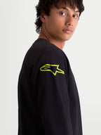 Alpinestars Velocifier CSF t-shirt, heren-t-shirt met lange mouwen, zwart met een felgeel Astars-logo op de schouder, close-up, op motorsport geïnspireerde casual sportswear.