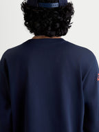 Alpinestars Velocifier CSF t-shirt met lange mouwen, sportswear t-shirt in blauw, achteraanzicht op model met een geribbelde ronde hals, op motorsport geïnspireerde vrijetijdskleding gemaakt van een zachte katoen- en gerecycled polyestermix.