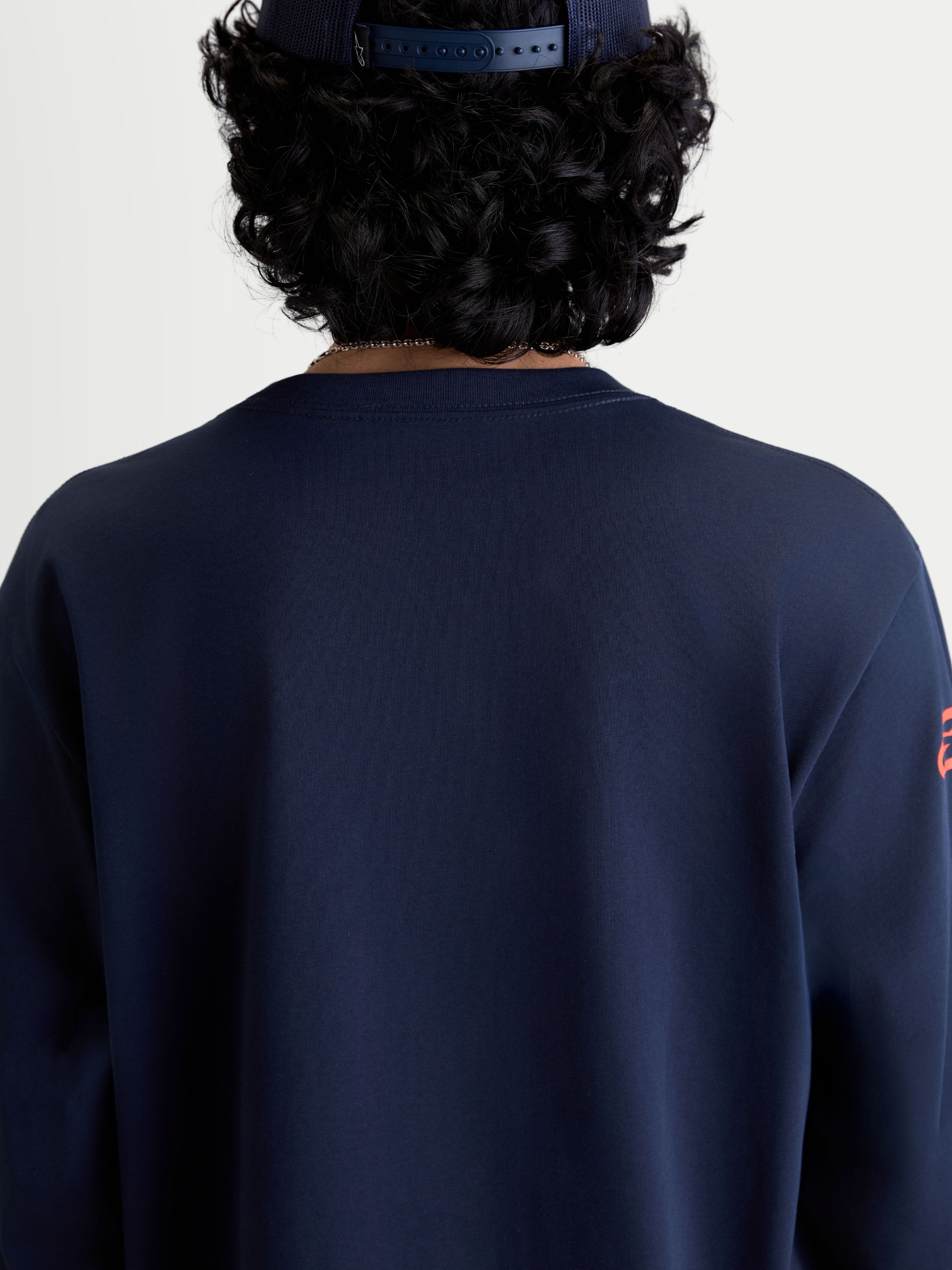 Alpinestars Velocifier CSF t-shirt met lange mouwen, sportswear t-shirt in blauw, achteraanzicht op model met een geribbelde ronde hals, op motorsport geïnspireerde vrijetijdskleding gemaakt van een zachte katoen- en gerecycled polyestermix.