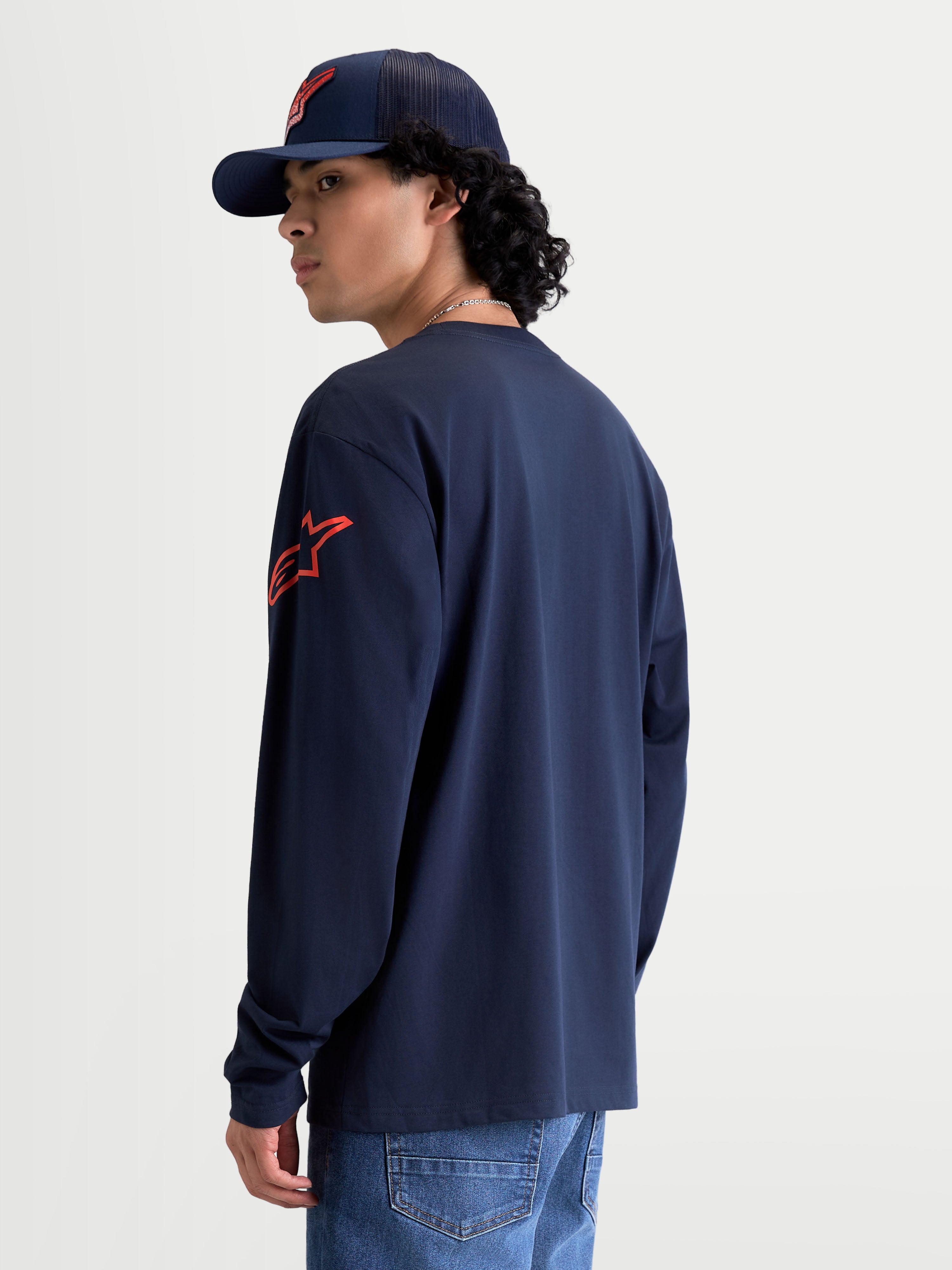 Alpinestars Velocifier CSF T-Shirt, sportswear T-shirt met lange mouwen, marineblauw en rood, met rood Astars-logo op de schouder en ribboorden, achteraanzicht op model, 80% katoen en 20% gerecycled polyester.