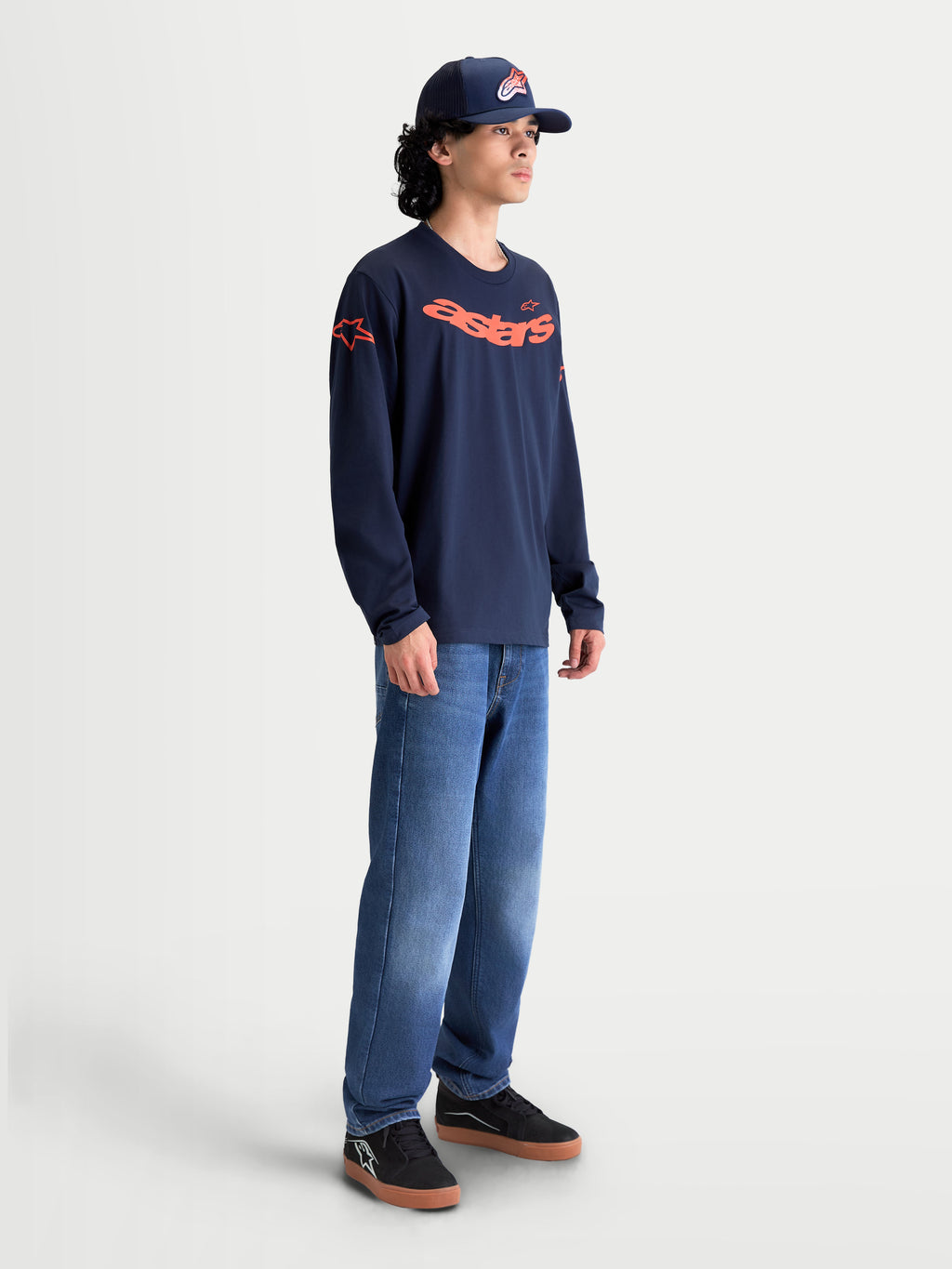 Alpinestars Velocifier CSF t-shirt met lange mouwen, heren sportswear shirt, donkerblauw en oranje, gebogen Astars-graphic en logo's op de schouders, katoen en gerecycled polyester mix, casual lifestyle uitstraling op model.