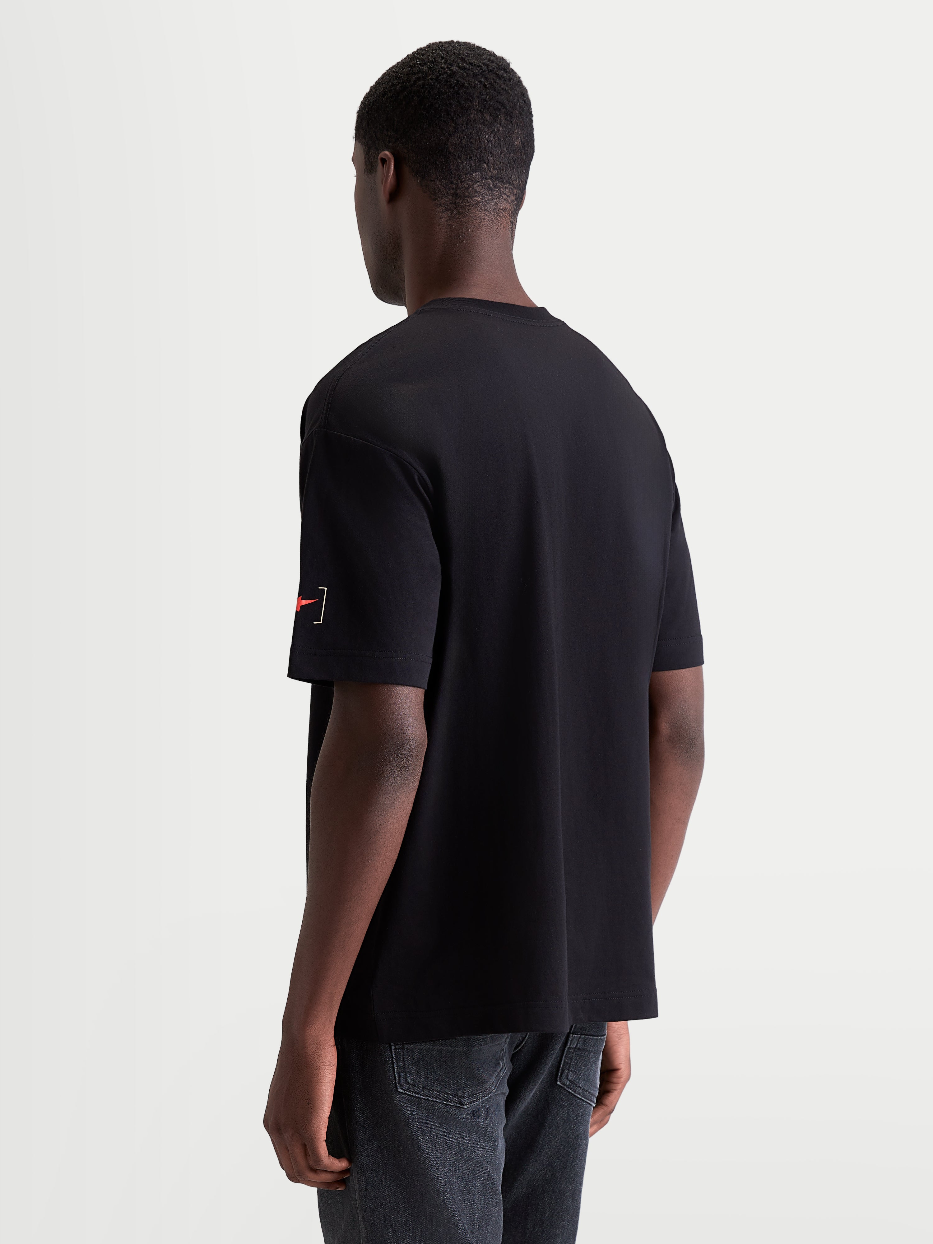 Alpinestars Infinity Oversized CSF T-Shirt, heren-sportswear T-shirt, zwart, oversized pasvorm, katoen-polyestermix, met een klein Astars bracket-logo op de mouw, driekwart achteraanzicht.
