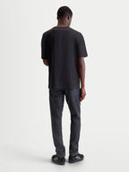 Alpinestars Infinity Oversized CSF t-shirt, zwart sportswear t-shirt met korte mouwen, achteraanzicht op model, relaxed fit voor dagelijks comfort en stijl naast de motor.