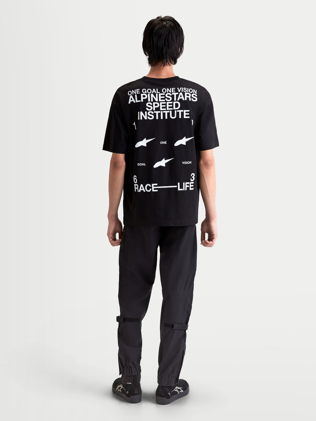 Alpinestars Institute Oversized CSF Tee, casual sportswear short sleeve t-shirt, black with white back logo graphics including 'Alpinestars Speed Institute' and 'One Goal One Vision', relaxed oversized fit, back view on-model.