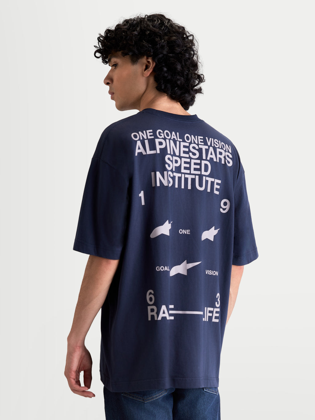 Alpinestars Institute Oversized SS CSF Tee, marineblauw heren t-shirt met korte mouwen en witte graphics, grote print op de achterzijde met Alpinestars Speed Institute en One Goal One Vision branding, ontspannen oversized pasvorm, casual sportswear.