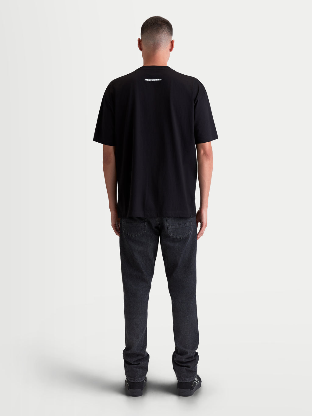 Alpinestars Prelude Oversized CSF t-shirt met korte mouwen, zwart, met Alpinestars-woordmerk op de bovenrug, achteraanzicht op model, casual lifestylekleding van zachte katoen-polyestermix.