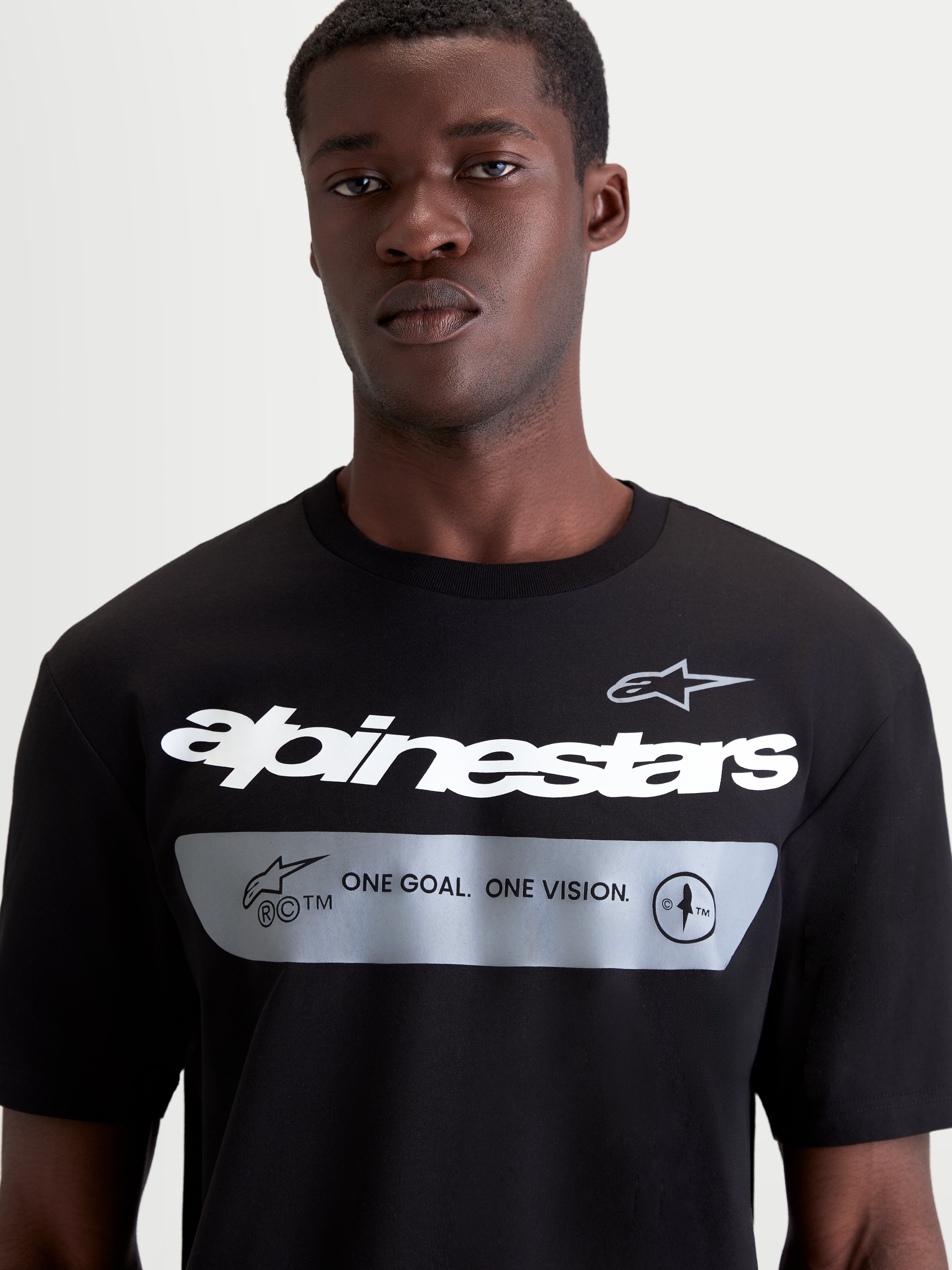 Alpinestars Singular CSF T-shirt met korte mouwen, zwart en wit, casual sportswear, katoenmix, close-up op model met Alpinestars woordgrafiek en ONE GOAL. ONE VISION. merkmanifesto.