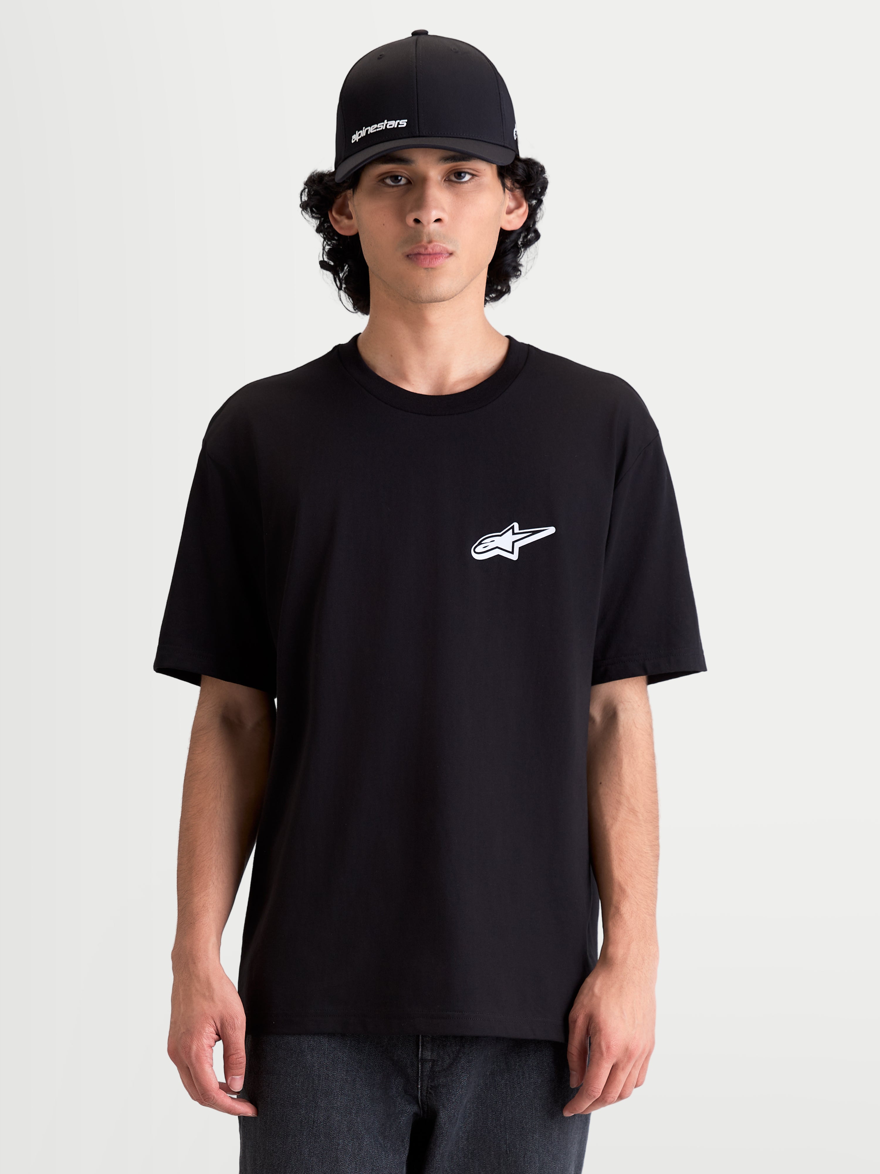 Alpinestars Meteor CSF T-shirt, heren-T-shirt met korte mouwen, zwart met een wit Astars-logo op de borst, casual motorsportkleding gedragen door een model.