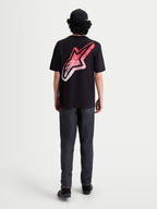 Alpinestars Meteor CSF t-shirt met korte mouwen, zwart, achteraanzicht op model met een groot Astars-logo op de rug voorzien van een rood en wit MX-kleurverloop, casual sportswear.
