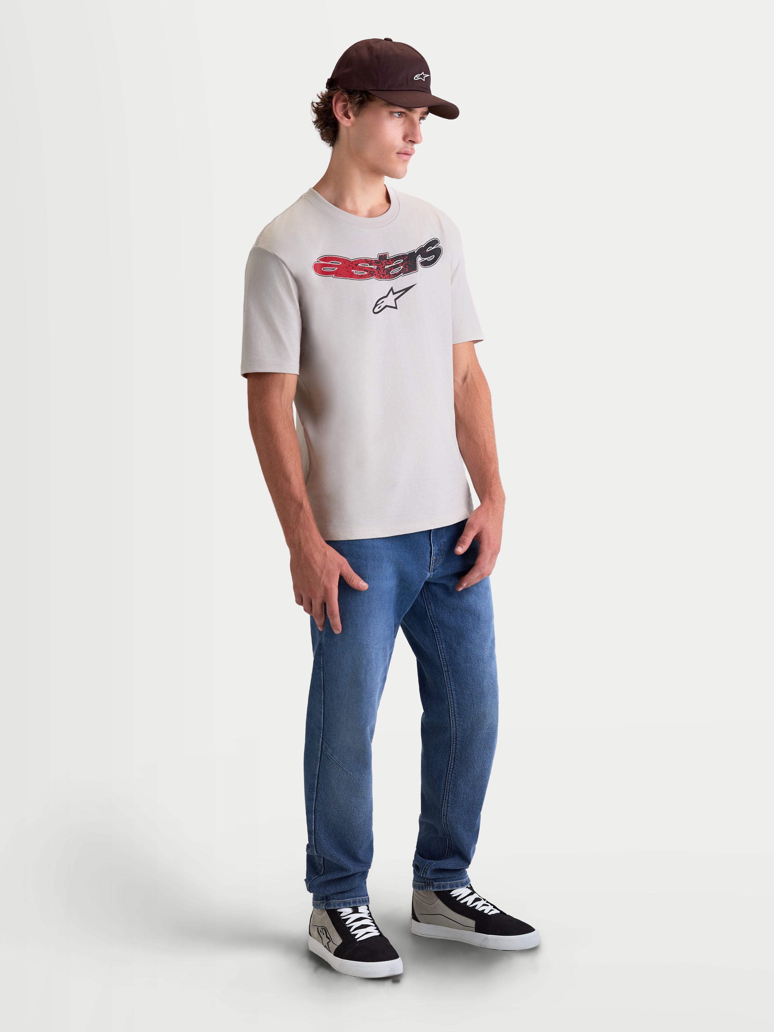 Alpinestars Elliptogrit CSF t-shirt, sportswear t-shirt met korte mouwen, cementgrijs, voorzien van een gebogen Astars-woordmerk met rood en zwart kleurverloop en zachte print, on-model volledige lichaamsopname voor een casual motorsport-geïnspireerde lifestyle-look.