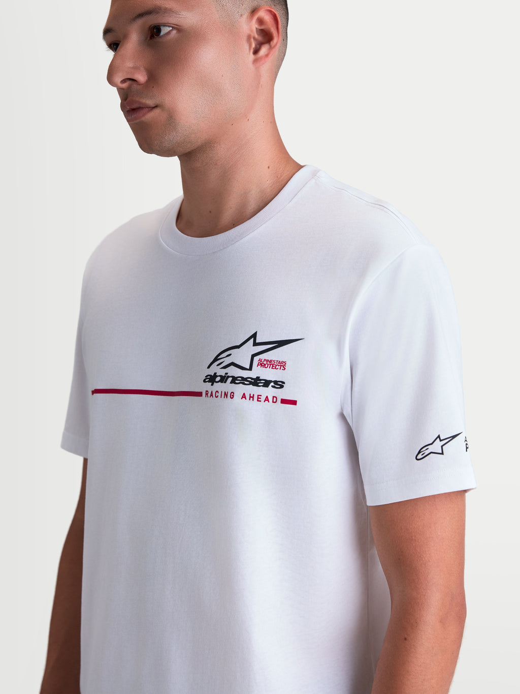Alpinestars P1 CSF T-shirt, wit t-shirt met korte mouwen, voorzien van een grafisch zwart en rood logo met racestreep op de borst, zachte katoen-polyestermix voor casual sportswear, gedragen door een model.