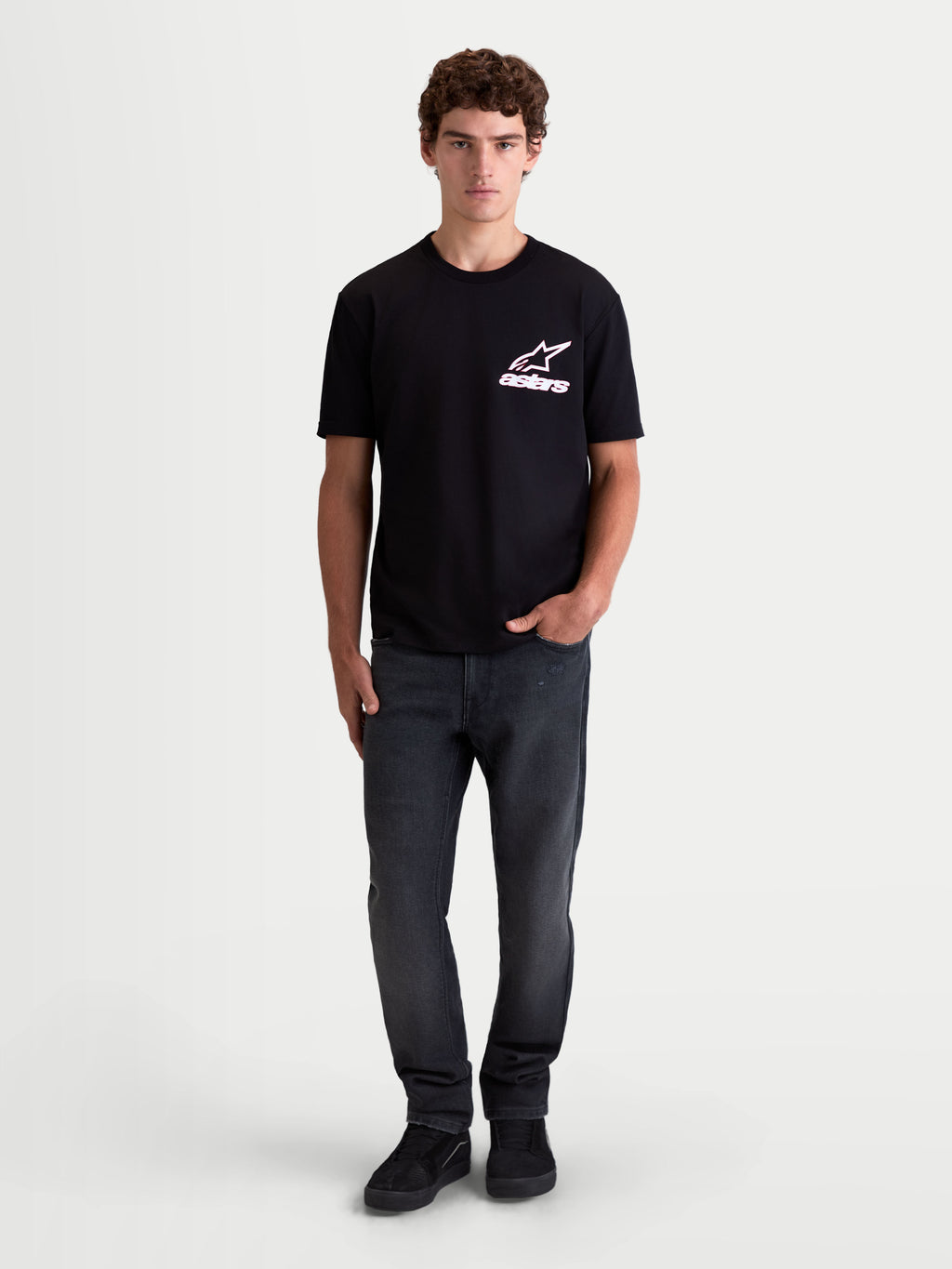 Alpinestars Lineout CSF t-shirt, heren-t-shirt met korte mouwen, zwart met wit en roze Astars-logo op de borst, op een model, zachte katoen-polyester mix, casual sportswear.