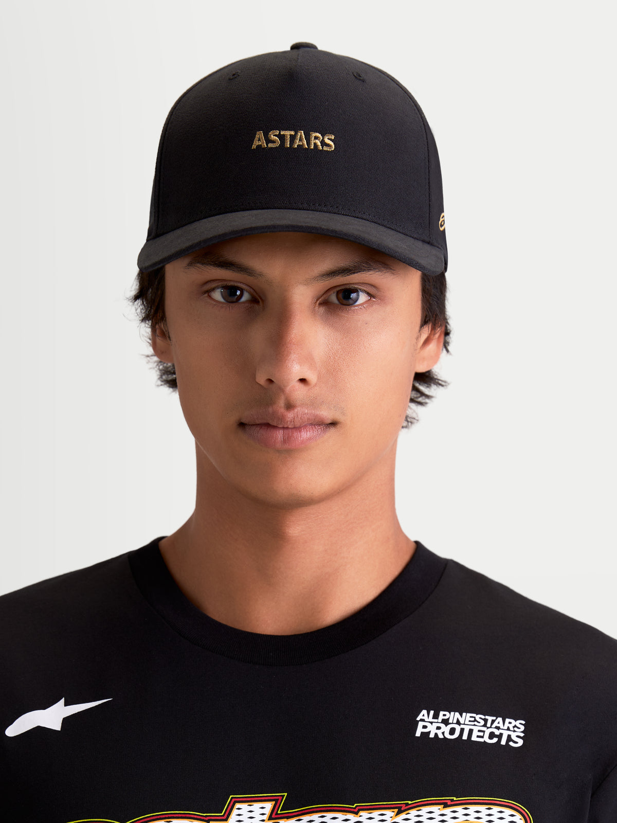 Alpinestars County Canvas pet, sportswear baseballpet met gebogen klep, zwart met gouden ASTARS-logoborduring, oxford peached stof en gestructureerde kroon, casual lifestylekleding op een model