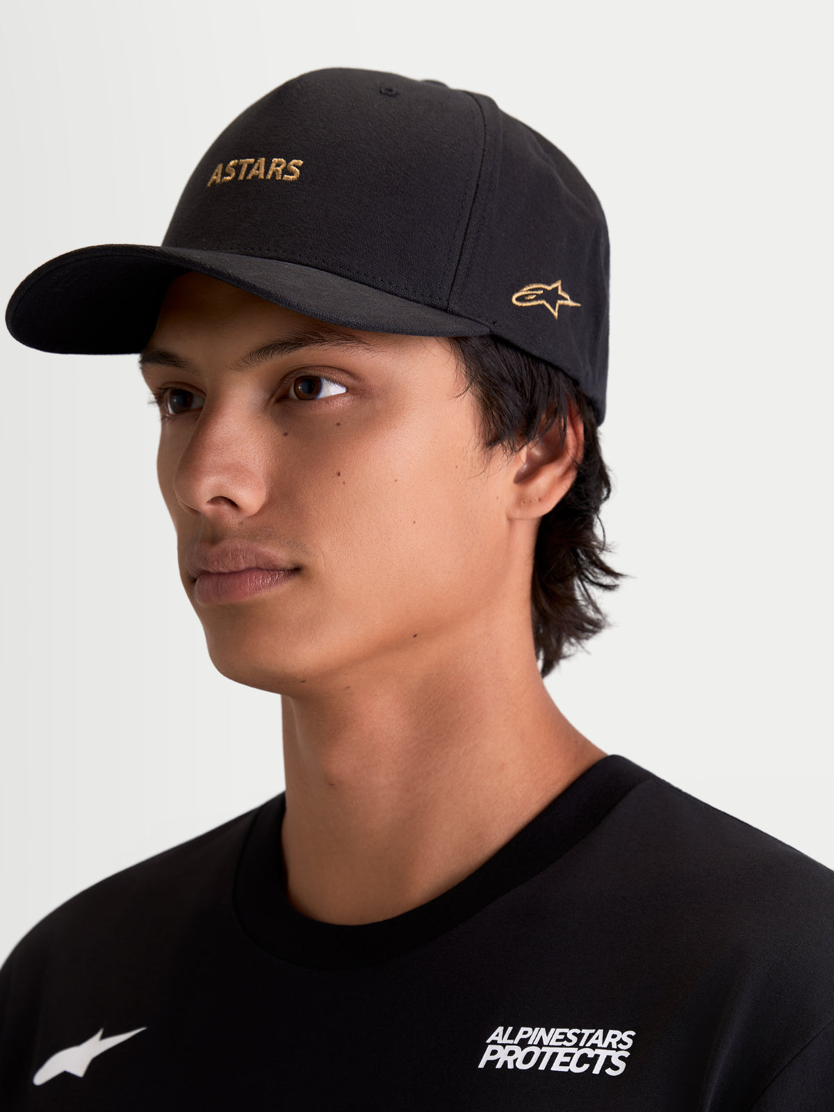 Alpinestars County Canvas pet, motorsport-geïnspireerde sportswearpet voor heren, zwart en goud, ASTARS-woordlogo en zijlogoborduring, gebogen klep en gestructureerde kroon, oxford peached canvasstof.