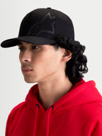 Alpinestars Maze pet, motorsport-geïnspireerde sportswear-pet voor heren, zwart, gestructureerde kroon, gebogen klep en getextureerd Astars Corp Shift-logo, zijprofiel op model