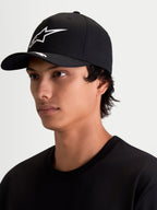 Alpinestars Arclight pet, sportswear baseballpet voor heren en dames, zwart en wit, gebogen klep, gestructureerde kroon, wit Astars-logo met puffprint en textuur, getoond op model.
