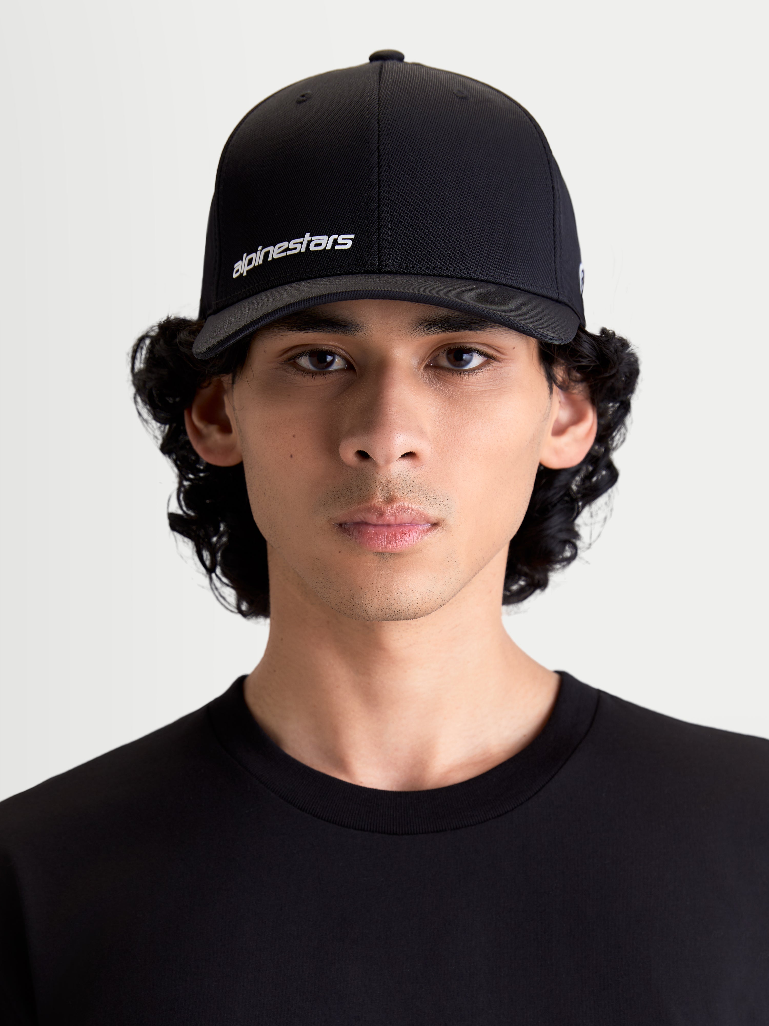 Alpinestars Points pet, sportswear baseballpet voor heren en dames, zwart met wit Alpinestars woordlogo, gebogen klep, lichtgewicht nylon tactel stof, flex-back pasvorm, vooraanzicht op model.