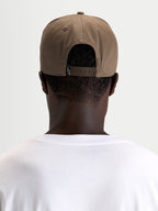 Alpinestars Acme Snapback Pet, casual sportswear pet, bruin, gedragen door een model, met verstelbare snapbacksluiting en achteraanzicht