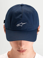 Alpinestars Dylan Dad Pet, blauwe casual sportswear pet gedragen door een model, met een gebogen klep en een geborduurd wit Astars-logo op de voorkant