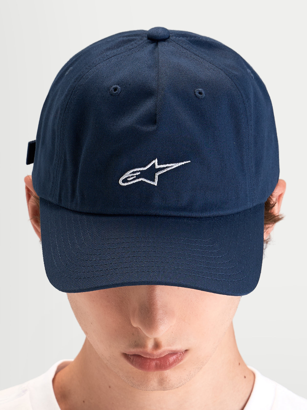 Alpinestars Dylan Dad Pet, blauwe casual sportswear pet gedragen door een model, met een gebogen klep en een geborduurd wit Astars-logo op de voorkant