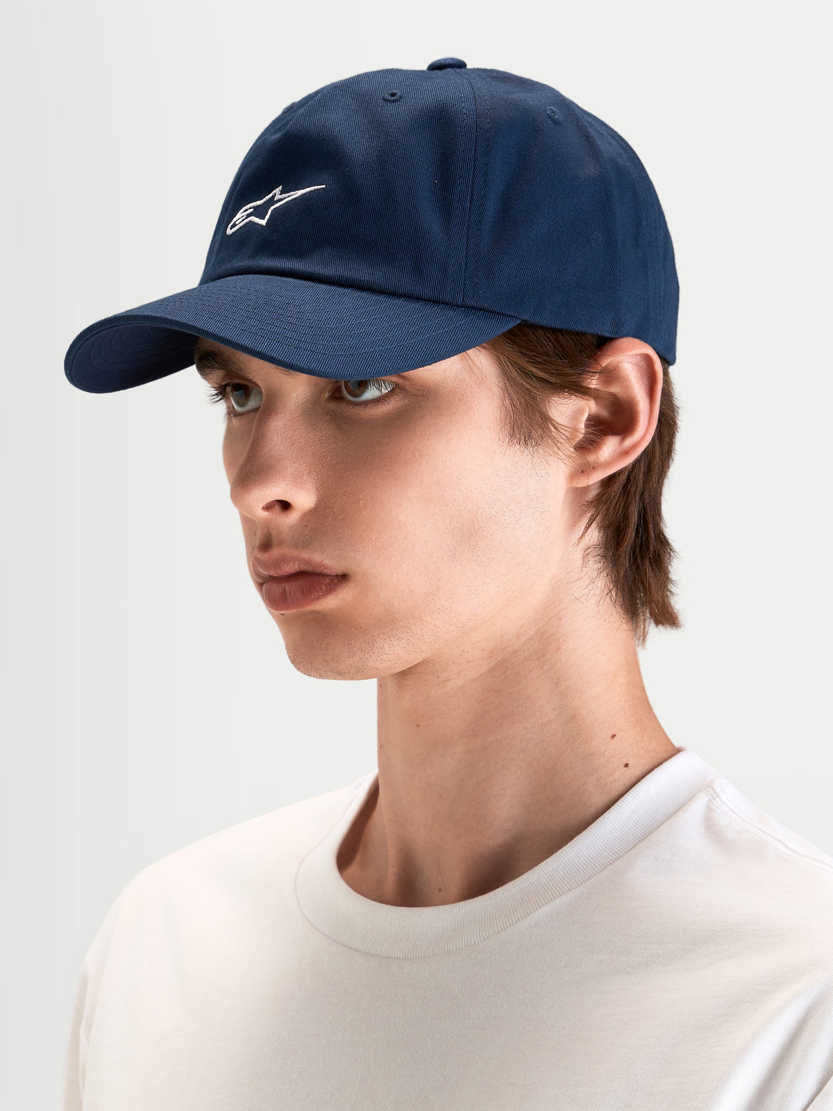 Alpinestars Dylan Dad Pet, casual sportswear pet in navyblauw met gebogen klep en wit Astars-logo borduursel, gedragen door model
