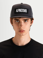 Alpinestars Ten Trucker pet, donkergrijze sportswear cap met platte klep en gestructureerde kroon, gedragen door een model, voorzien van een geborduurde Alpinestars woordlogopatch op de voorzijde