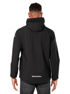 Alpinestars Kascade regenjas, regenjas voor heren, zwart, achteraanzicht met vaste capuchon en Alpinestars-logo op de onderrug, casual waterdichte sportkleding
