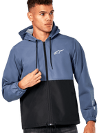 Alpinestars Speeder Windbreaker Jas, blauw en zwart design met kleurvlakken, capuchon met zwarte trekkoorden, wit logo op de borst, casual motorsport-geïnspireerde windbreaker, mannelijk model