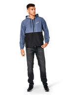 Alpinestars Speeder Windbreaker jas, Slate Blue en zwart, lichtgewicht jack met capuchon en mesh voering, wit sterlogo op de borst, gedragen met zwarte jeans en sneakers, casual motorsport streetwear design.
