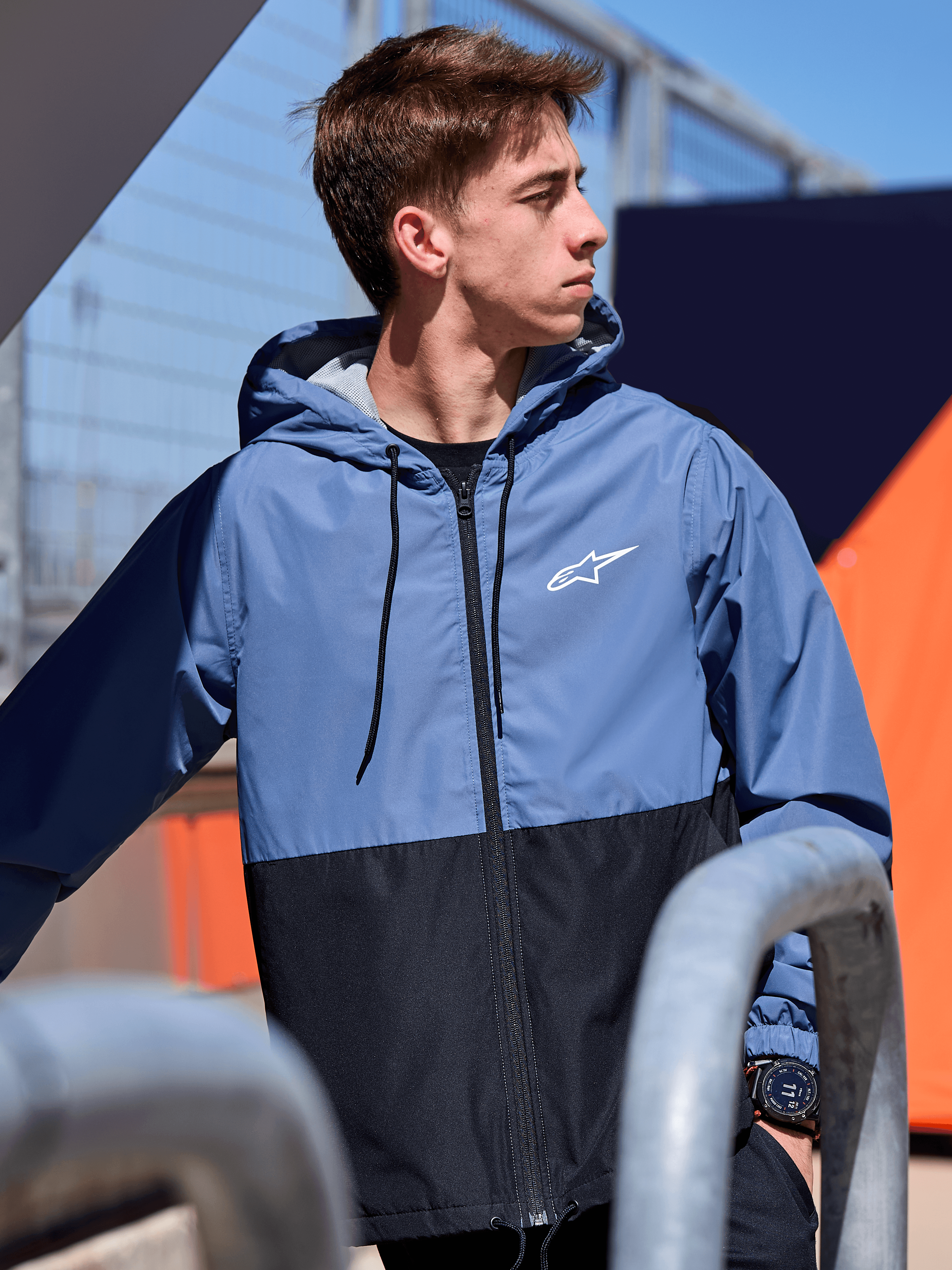 Alpinestars Speeder Windbreaker jas, lichtgewicht windbreaker met capuchon, Slate Blue en zwart kleurblokontwerp, wit Alpinestars-logo op de borst, mesh-gevoerd met trekkoord bij de capuchon, casual motorsport-geïnspireerde streetwear