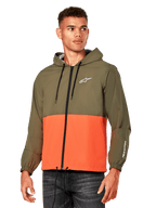 Alpinestars Speeder Windbreaker Jas, lichtgewicht windbreaker met capuchon, Military Orange en olijfgroen, color-block ontwerp met wit logo op de borst en mouw, casual motorsport-geïnspireerde jas, persoon draagt de jas