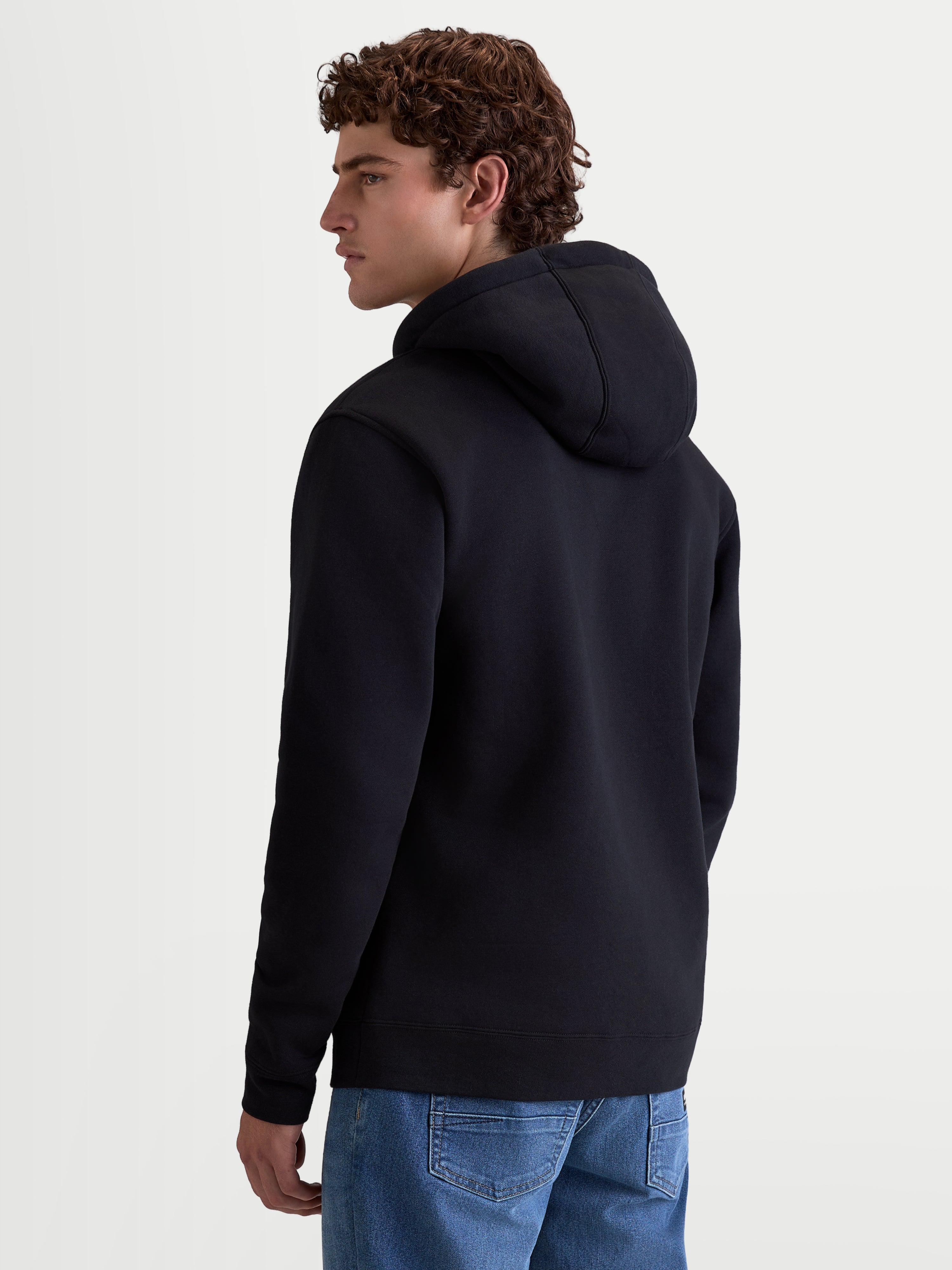 Alpinestars Ageless V3 hoodie, herensportswear pullover fleece, zwart, zachte katoen- en gerecyclede polyestermix, achteraanzicht met capuchon en geribde manchetten, comfortabele lifestyle-kleding voor motorsportliefhebbers.