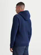 Alpinestars Ageless V3 hoodie, casual sportswear-pulloverfleece, marineblauw, achteraanzicht op model, voorzien van een gevoerde capuchon en geribde manchetten en zoom, premium katoen en gerecycled polyester.