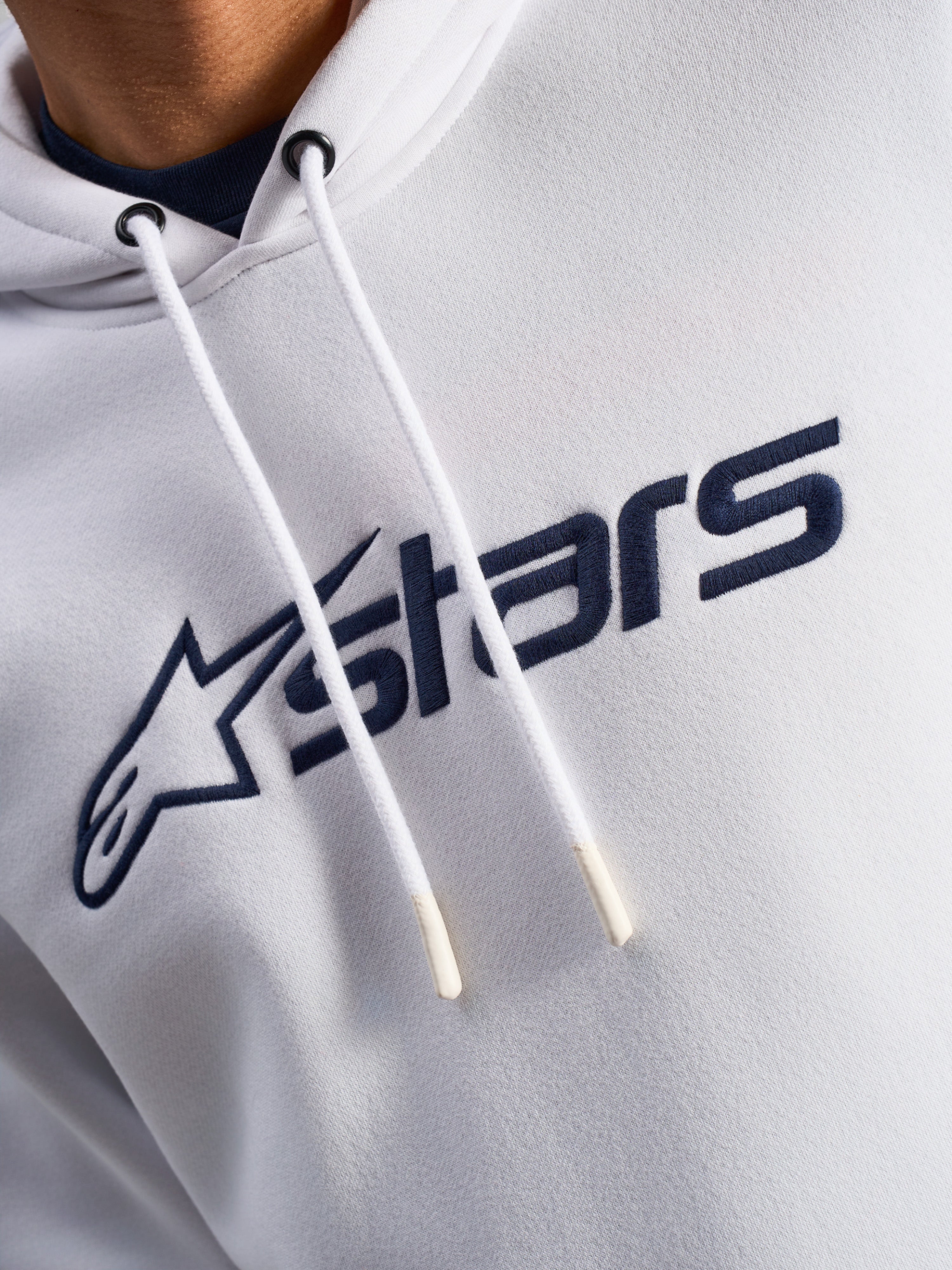 Alpinestars Blaze V3 Hoodie, White Navy, close-up of chest featuring navy blue front logo print and white drawstrings with dipped tips, casual motorsport streetwear