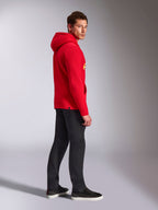 Alpinestars Ride V3 Hoodie, casual sportkleding, rood met Hi-Vis gele branding, mannelijk model draagt rode hoodie met zwarte broek en sneakers, zijaanzicht, pullover fleece ontwerp met geribde manchetten en zoom
