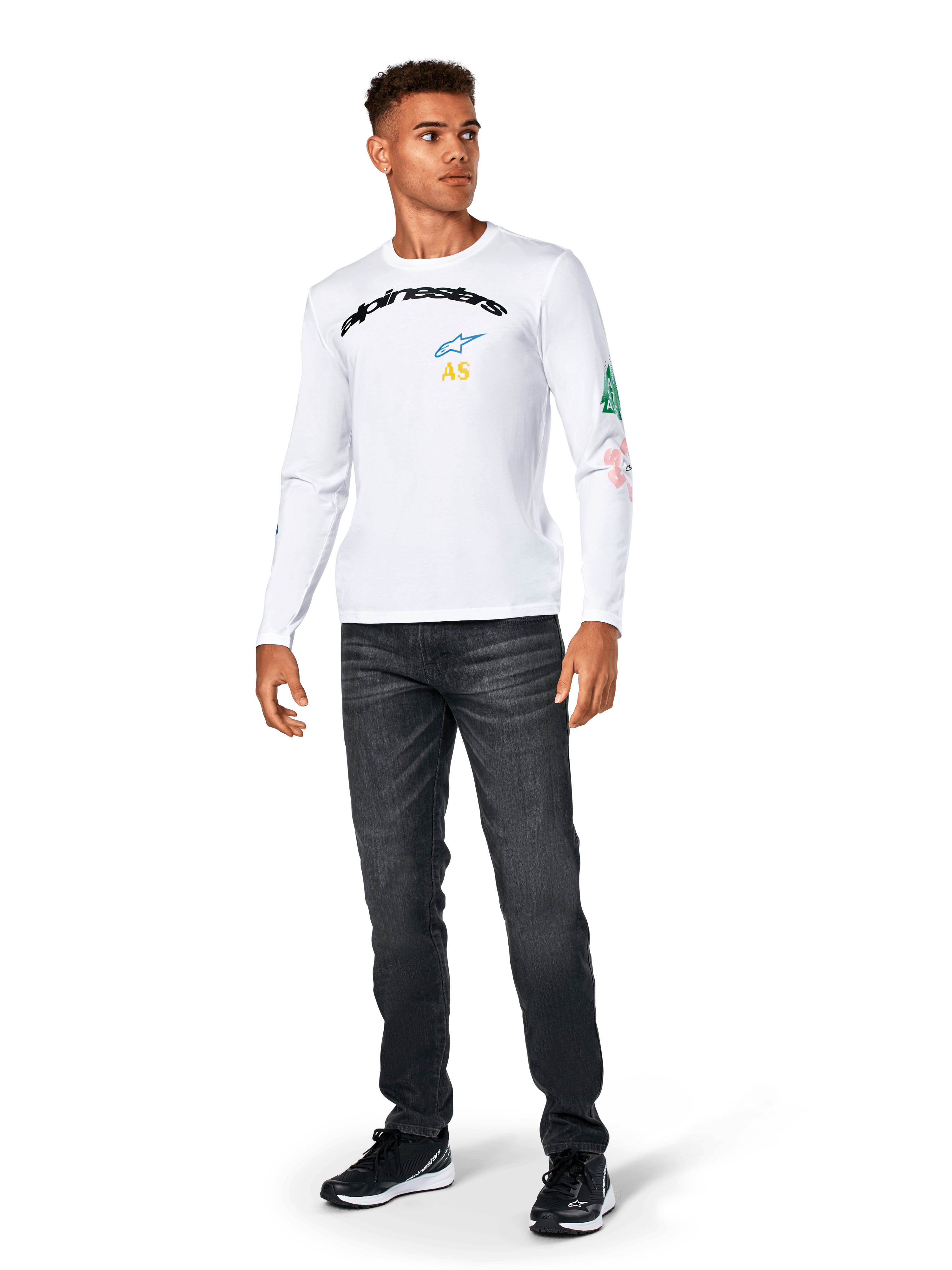 Alpinestars Brundo CSF Tee - lange mouwen, wit, casual sportkleding, voorzien van zwarte 'alpinestars' tekst op de borst, een blauw sterlogo en gele 'AS' initialen, kleurrijke graphics op de mouw, gedragen met donkere jeans en zwarte sneakers.