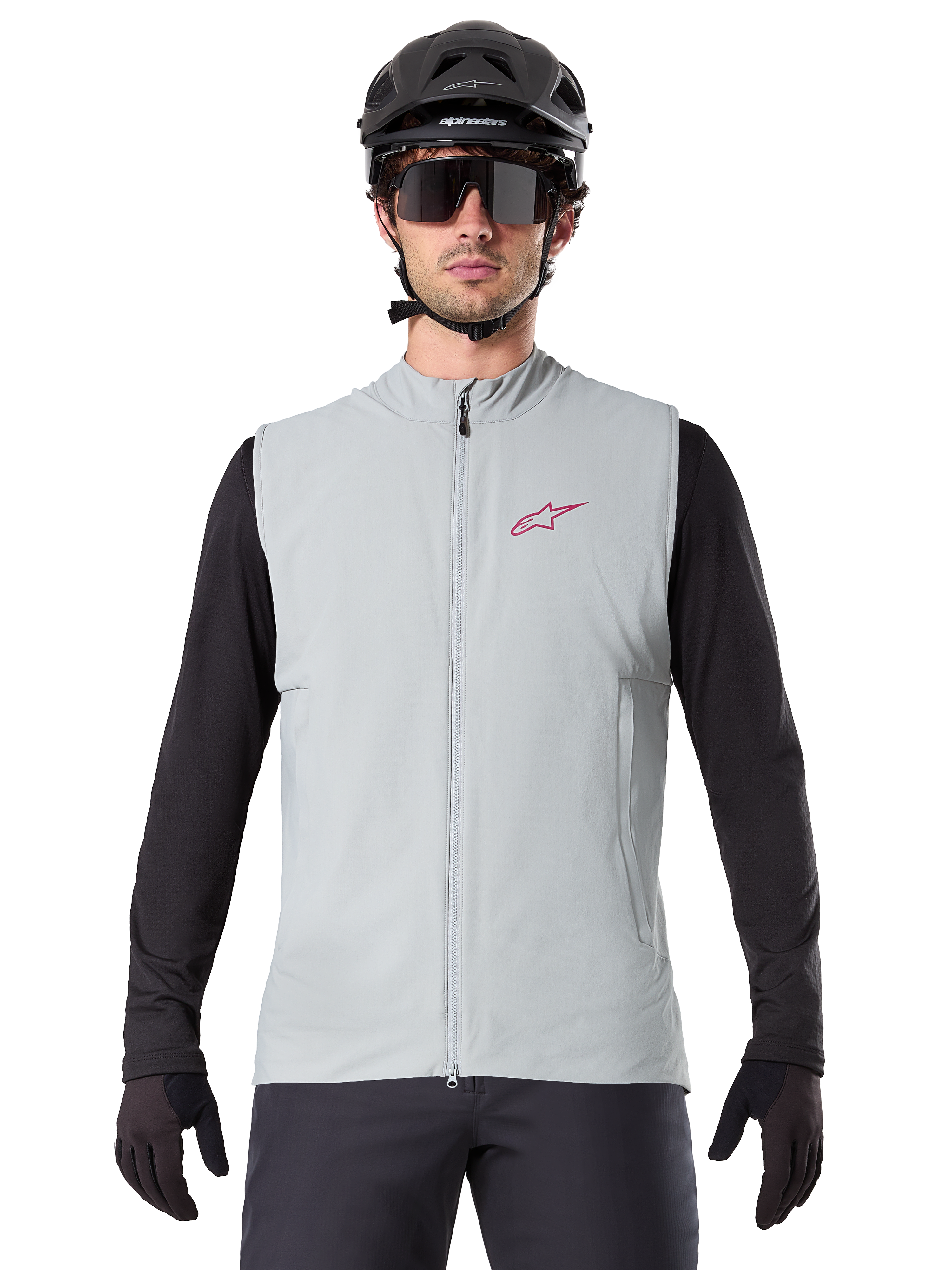 Alpinestars A-Dura Thermal Vest, fietsbodywarmer, Titanium grijs, gedragen met een zwarte jersey met lange mouwen en zwarte fietshelm, rood Alpinestars ster-logo op de borst, lichtgewicht en geïsoleerd voor mountainbiken.