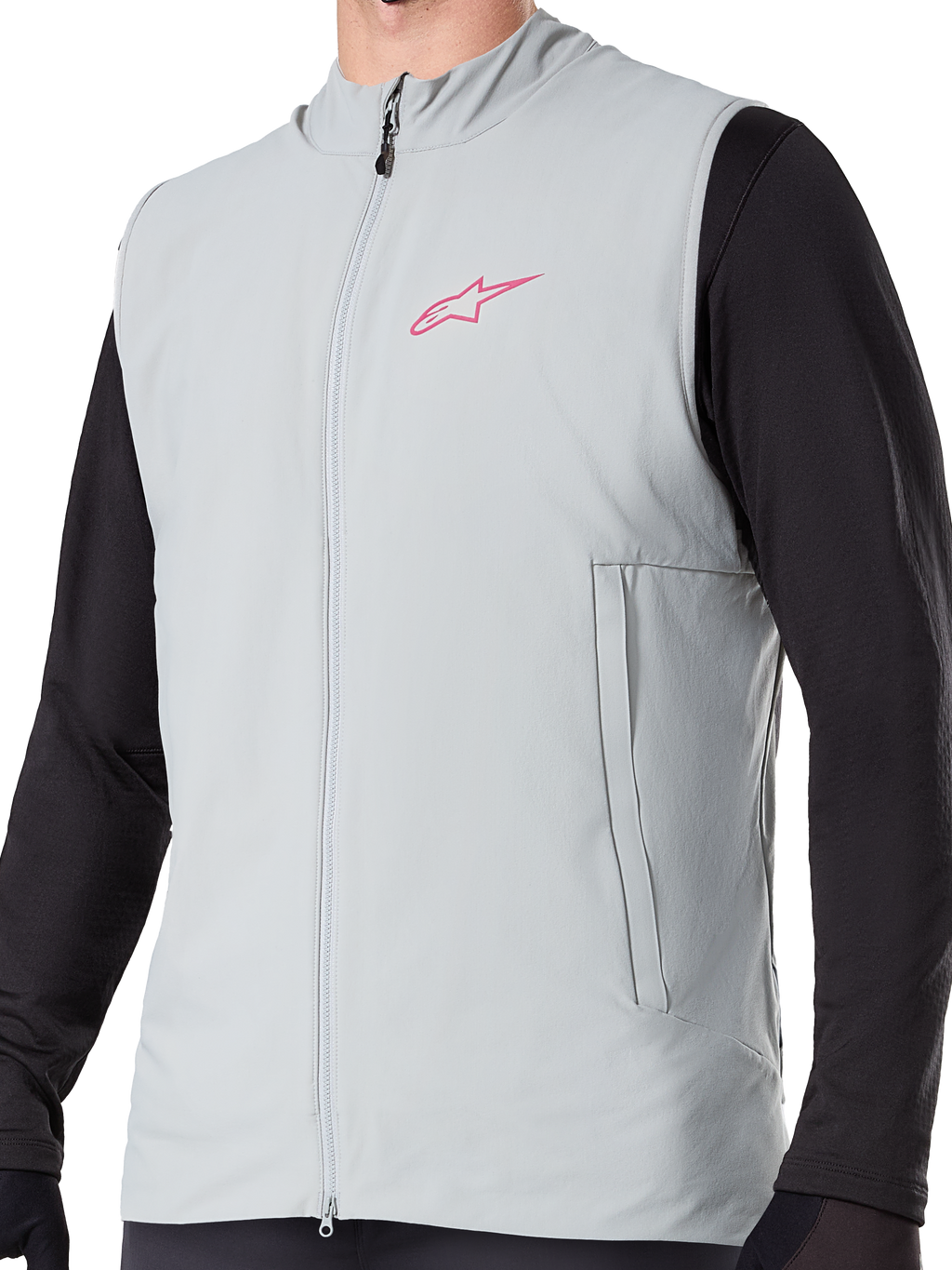 Alpinestars A-Dura Thermal Vest, titanium grijs geïsoleerd fietsvest, voorzien van een roze sterlogo op de borst, gedragen over een zwarte top met lange mouwen, inclusief een verticale zak met ritssluiting en volledige rits aan de voorzijde, ontworpen voor mountainbiken in koud weer.