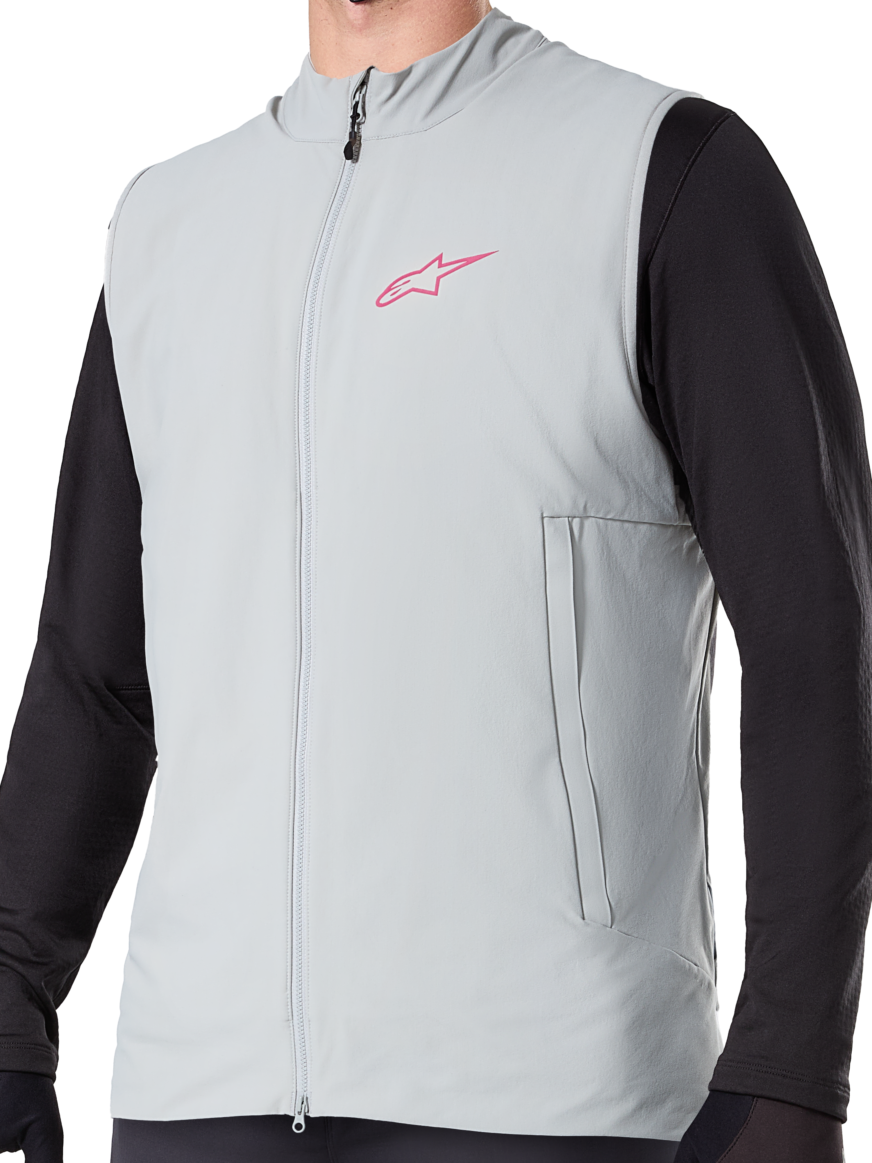 Alpinestars A-Dura Thermal Vest, titanium grijs geïsoleerd fietsvest, voorzien van een roze sterlogo op de borst, gedragen over een zwarte top met lange mouwen, inclusief een verticale zak met ritssluiting en volledige rits aan de voorzijde, ontworpen voor mountainbiken in koud weer.