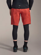 Alpinestars A-Motion Plasma Knee Sleeve, zwarte MTB-kniebeschermers, achteraanzicht gedragen onder een rode mountainbikebroek met een zwart fietsshirt en technische fietsschoenen, beschermende uitrusting voor mountainbiken
