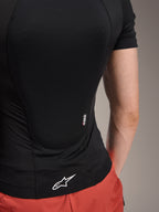 Alpinestars A-Motion Plasma Protection Jacket - Short Sleeve, Black Camo, Rear view detail showing Nucleon PLASMA branding and white Alpinestars logo on the hem, breathable stretch mesh construction for MTB protection