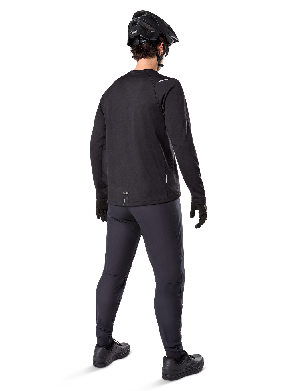 Alpinestars A-Dura Thermal Pant, mountainbike broek, zwart, achteraanzicht, gedragen met een bijpassend shirt met lange mouwen, zwarte MTB-helm en handschoenen, technische fietskleding voor koud weer