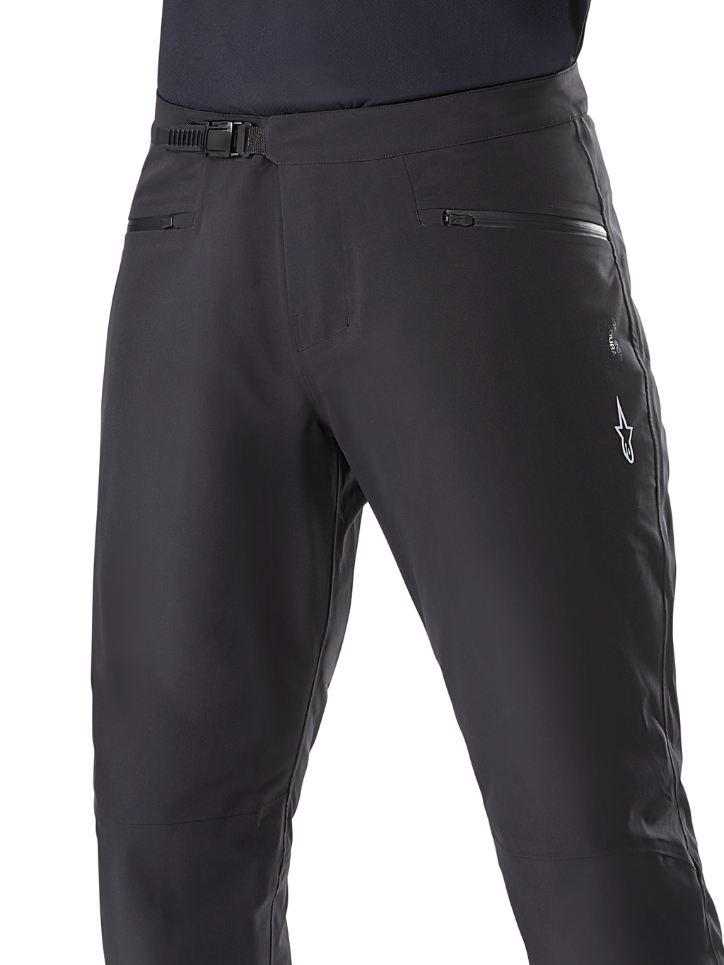 Alpinestars A-Dura Waterproof Pants, mountainbikebroek, zwart, close-up van de taille met ratelsluiting en zakken met rits, met een wit Alpinestars-logo op de dij, duurzaam textiel voor trailrijden in natte weersomstandigheden