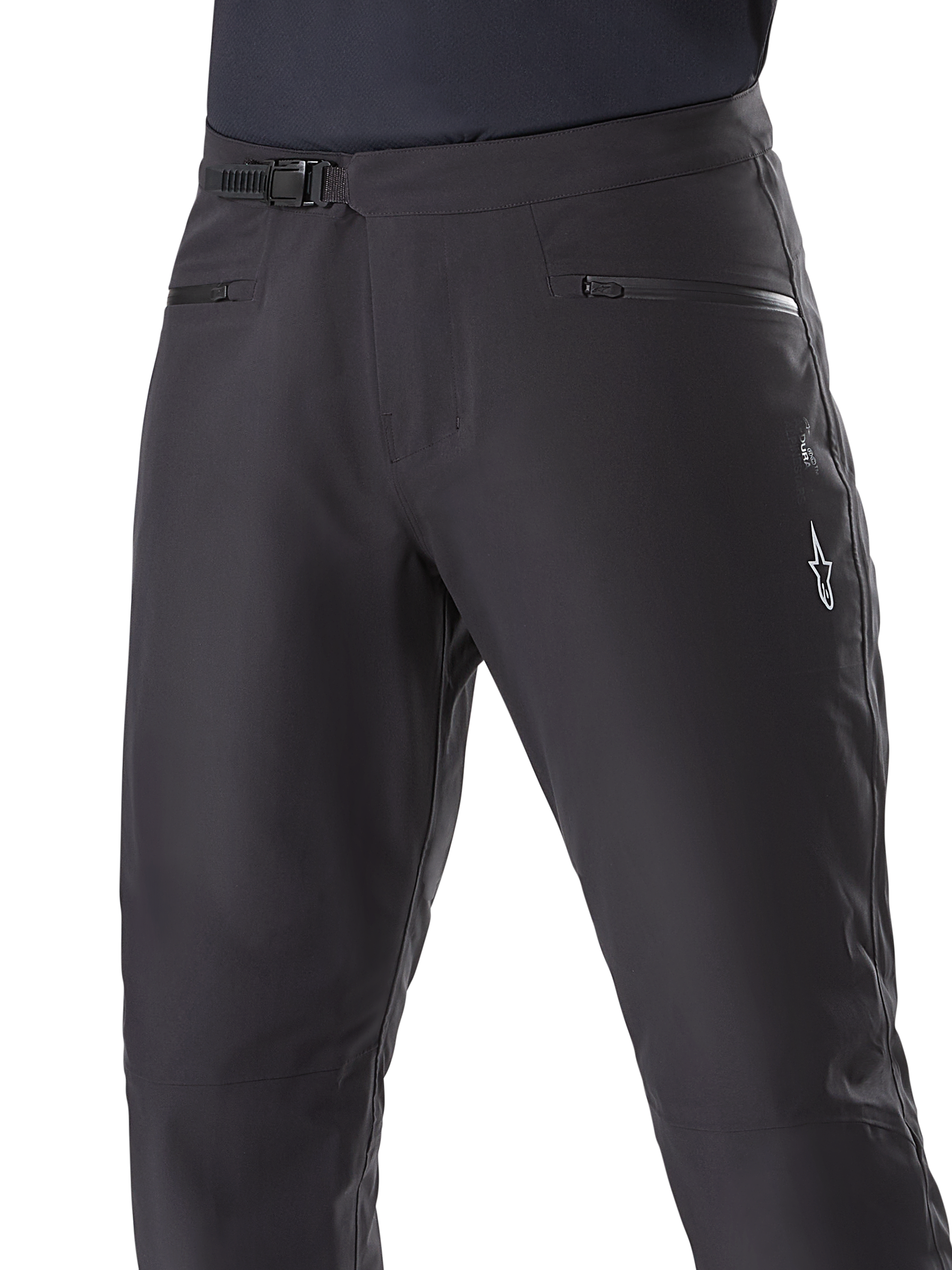 Alpinestars A-Dura Waterproof Pants, mountainbikebroek, zwart, close-up van de taille met ratelsluiting en zakken met rits, met een wit Alpinestars-logo op de dij, duurzaam textiel voor trailrijden in natte weersomstandigheden