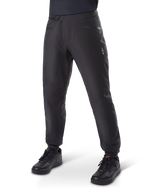 Alpinestars A-Dura Waterproof Pants, MTB-broek, zwart, voorzien van een ratelsluiting bij de taille, zakken met ritssluiting en een wit Astars-logo op de dij, gedragen met zwarte fietsschoenen voor trailrijden in alle weersomstandigheden.