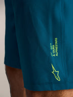 A-Dura Ride MTB-shorts in blauwgroen, met limoengroene Alpinestars-branding en logo op geweven stretchstof.